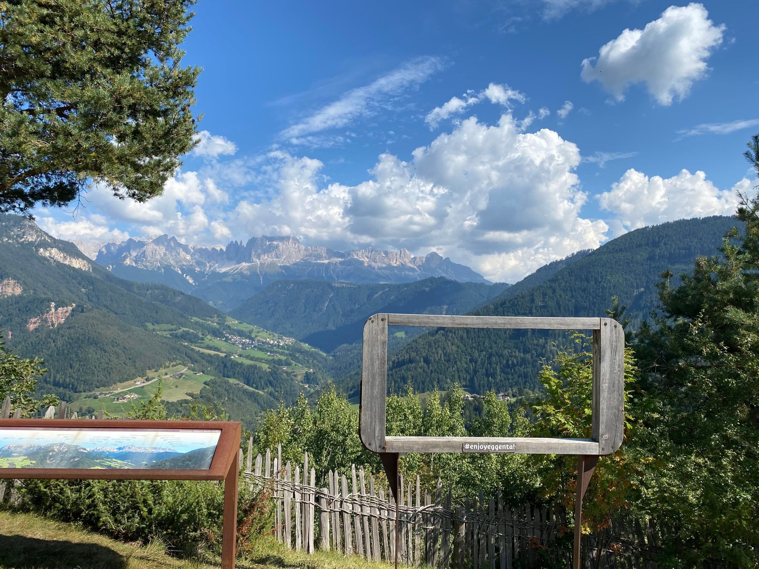 Holzrahmen eines Aussichtspunkts mit Blick auf Wälder und die Dolomiten